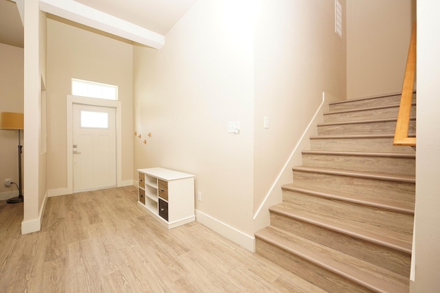 entrance foyer featuring stairway, baseboards, and wood finished floors
