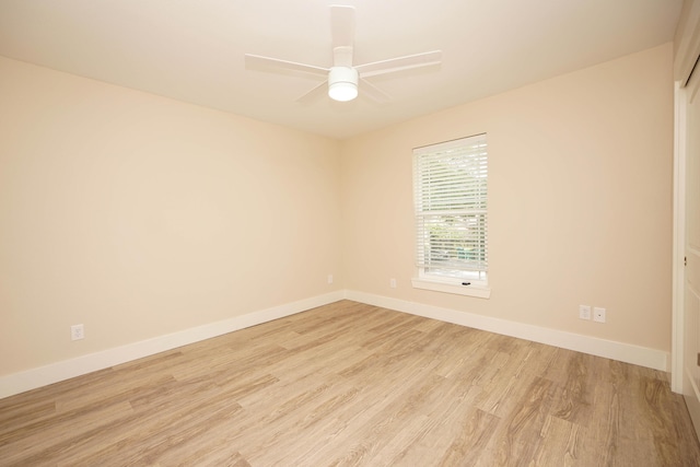 empty room with baseboards, ceiling fan, and light wood-type flooring