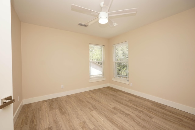 spare room featuring visible vents, light wood-style floors, and baseboards
