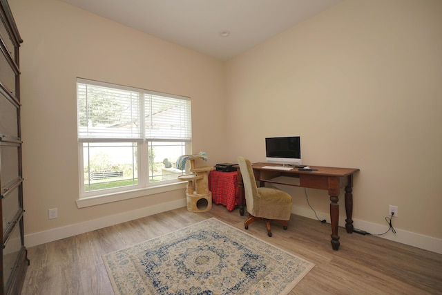 home office featuring baseboards, plenty of natural light, and wood finished floors