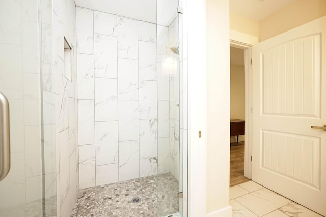 bathroom with a marble finish shower and marble finish floor