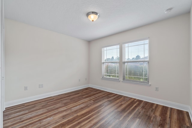 2690 Hartman Ct, Navarre, FL 32566 - unfurnished room with wood finished floors, baseboards, and a textured ceiling