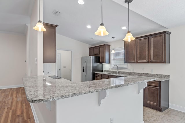 2690 Hartman Ct, Navarre, FL 32566 - kitchen featuring a sink, dark brown cabinetry, a peninsula, a kitchen breakfast bar, and stainless steel refrigerator with ice dispenser