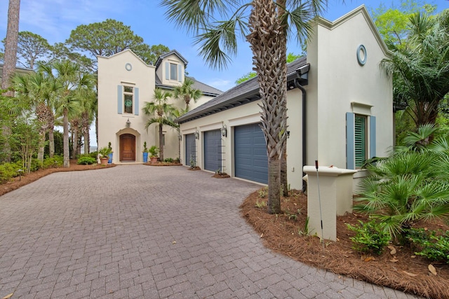 3002 Bay Villas Dr, Miramar Beach, FL 32550 - mediterranean / spanish-style house with stucco siding, decorative driveway, and an attached garage