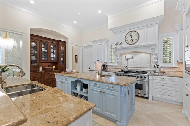 3002 Bay Villas Dr, Miramar Beach, FL 32550 - kitchen with stainless steel range, a sink, a center island with sink, white cabinets, and recessed lighting