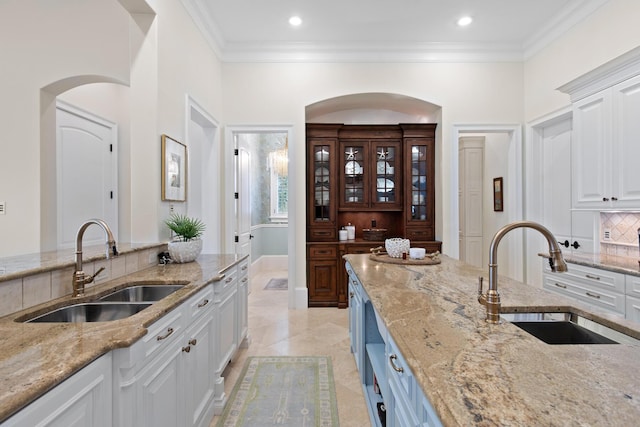 3002 Bay Villas Dr, Miramar Beach, FL 32550 - kitchen featuring a sink, tasteful backsplash, white cabinetry, light stone countertops, and crown molding