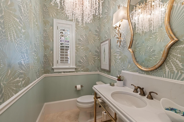 3002 Bay Villas Dr, Miramar Beach, FL 32550 - half bath with wallpapered walls, tile patterned flooring, toilet, a chandelier, and vanity