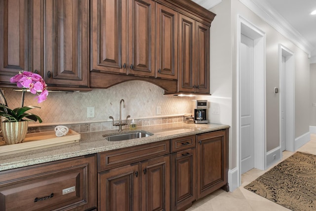 3002 Bay Villas Dr, Miramar Beach, FL 32550 - kitchen featuring a sink, backsplash, light stone countertops, ornamental molding, and dark brown cabinetry