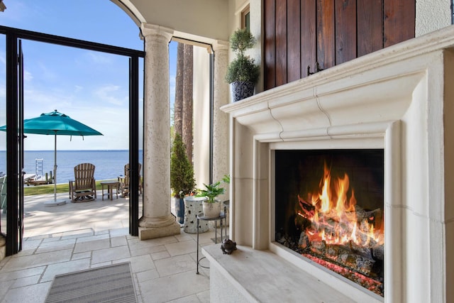 3002 Bay Villas Dr, Miramar Beach, FL 32550 - detailed view of a warm lit fireplace, decorative columns, a water view, and board and batten siding