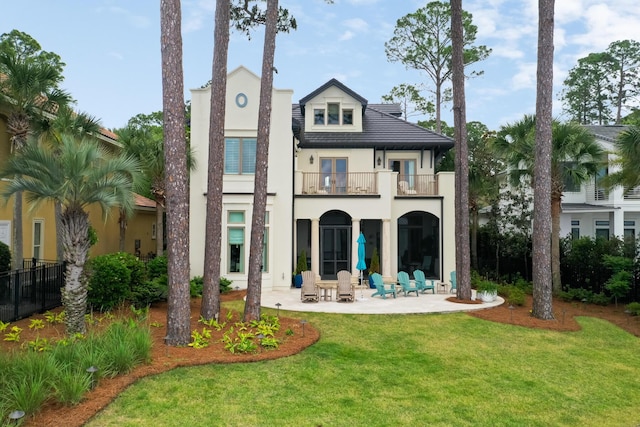 3002 Bay Villas Dr, Miramar Beach, FL 32550 - back of property featuring a balcony, a patio area, stucco siding, and a lawn