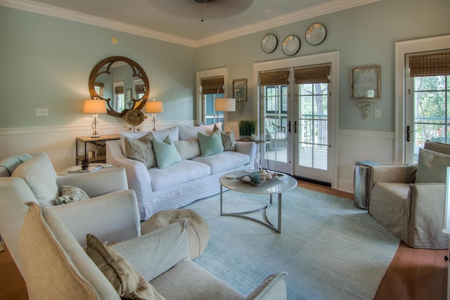 living room featuring crown molding, ceiling fan, wainscoting, and wood finished floors