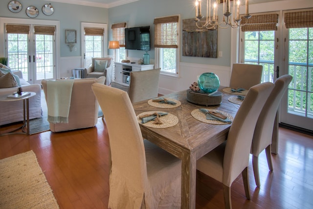 dining room with crown molding, an inviting chandelier, wainscoting, and french doors
