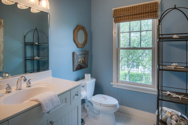 bathroom with tile patterned floors, vanity, toilet, and a wealth of natural light