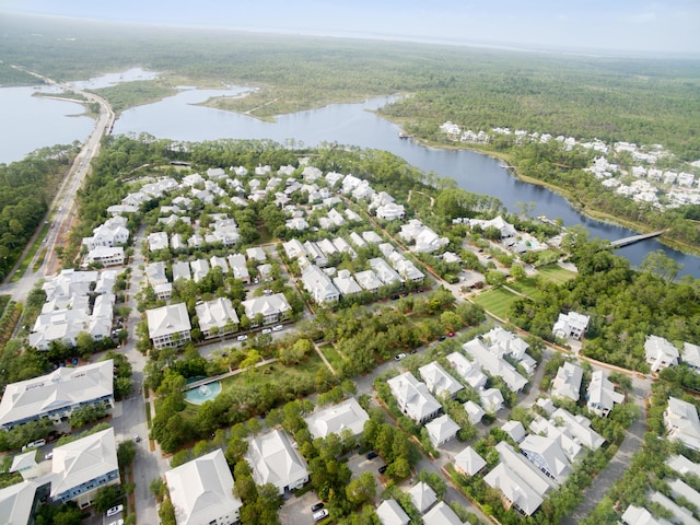 drone / aerial view featuring a water view, a residential view, and a forest view