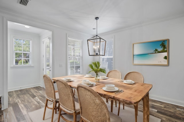 dining room featuring crown molding, visible vents, an inviting chandelier, and wood finished floors