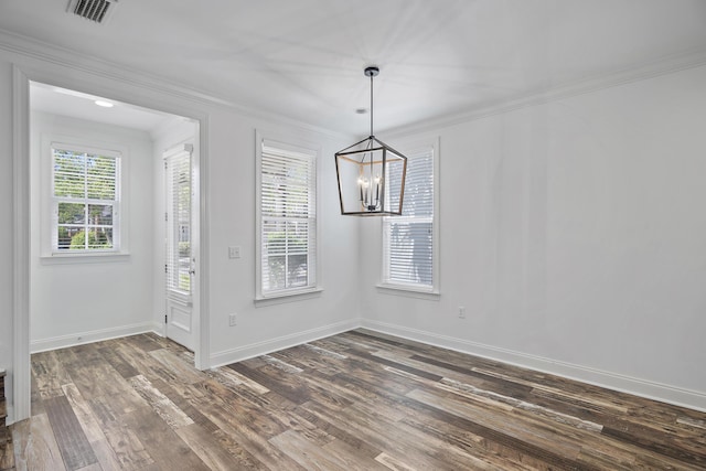 unfurnished dining area featuring visible vents, dark wood finished floors, baseboards, a notable chandelier, and ornamental molding
