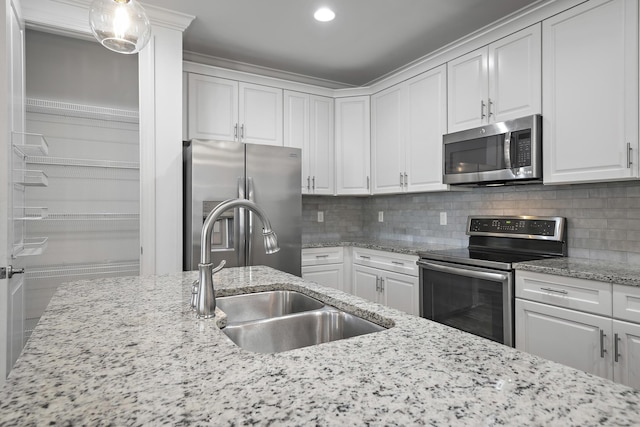 kitchen featuring backsplash, white cabinetry, appliances with stainless steel finishes, and a sink