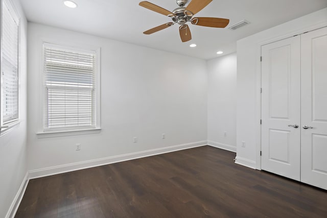 unfurnished bedroom with visible vents, dark wood finished floors, and baseboards
