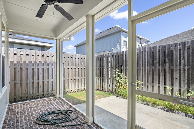 unfurnished sunroom featuring a ceiling fan