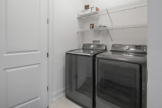 laundry room featuring baseboards and washing machine and clothes dryer