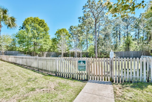 exterior space with fence and a lawn