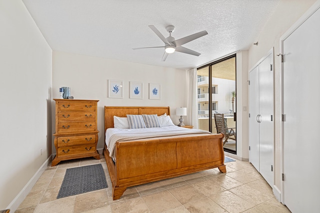 100 Gulf Shore Dr Unit 202, Destin, FL 32541 - bedroom with baseboards, stone tile floors, a ceiling fan, and access to exterior