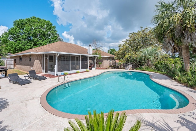 view of swimming pool featuring a fenced in pool, fence, a sunroom, and a patio area