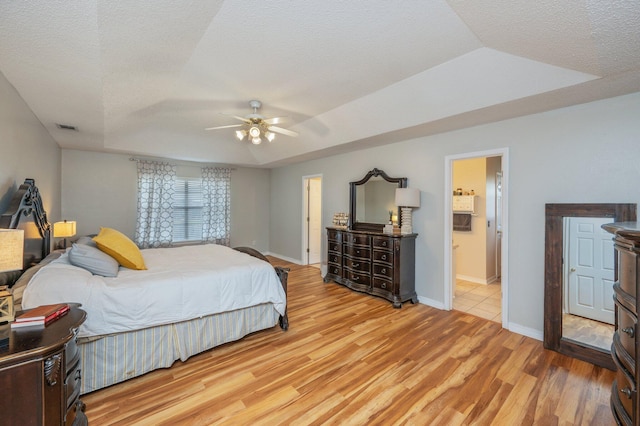 bedroom featuring a textured ceiling, baseboards, ceiling fan, and light wood-style flooring