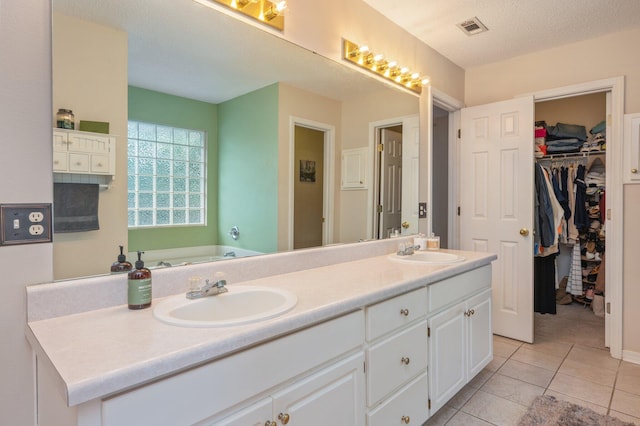 bathroom with visible vents, a sink, tile patterned floors, and double vanity