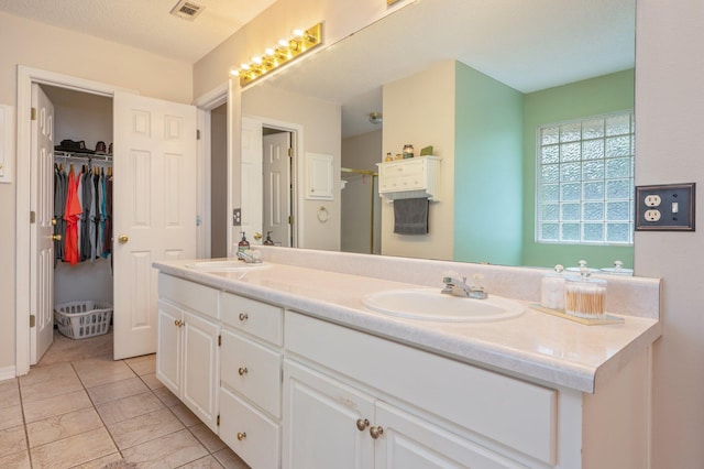 full bathroom featuring a sink, a shower stall, double vanity, and visible vents