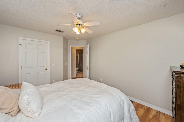 bedroom with a ceiling fan, baseboards, visible vents, and light wood finished floors