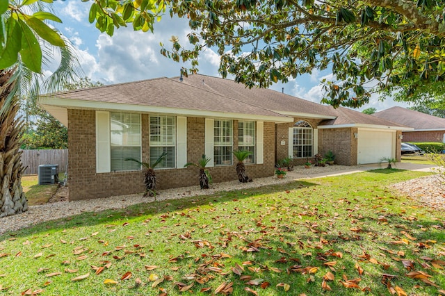 ranch-style home featuring an attached garage, fence, a front yard, and brick siding