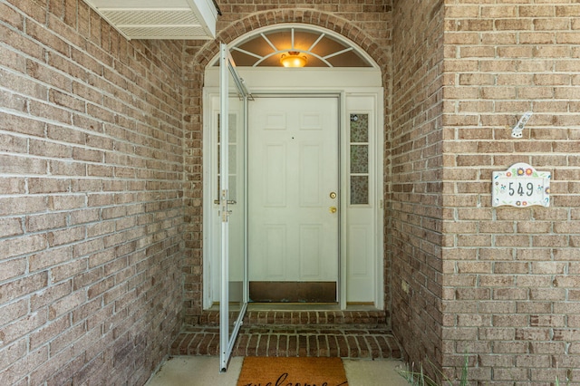 entrance to property featuring brick siding