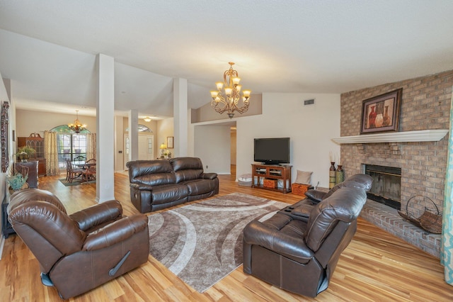 living area featuring visible vents, a chandelier, and light wood finished floors