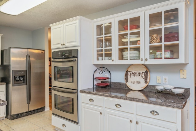 kitchen featuring white cabinetry, appliances with stainless steel finishes, and glass insert cabinets
