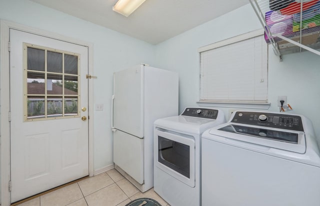 washroom with light tile patterned flooring, laundry area, and washing machine and dryer