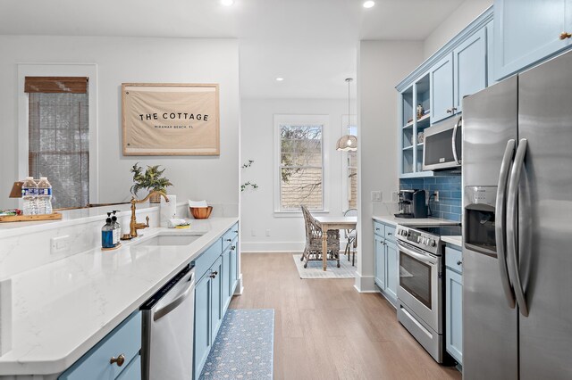 97 Sarasota St, Miramar Beach, FL 32550 - kitchen featuring a sink, stainless steel appliances, recessed lighting, light wood-type flooring, and blue cabinets