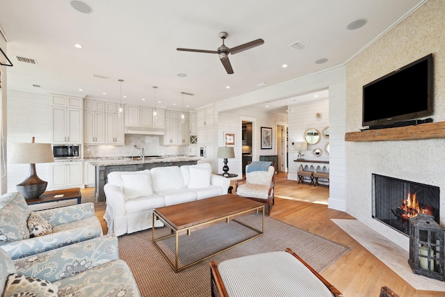68 Creek Bridge Way, Watersound, FL 32461 - living room featuring light wood-style floors, ceiling fan, a fireplace, and visible vents
