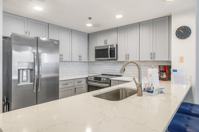 1751 Scenic Highway 98 Unit 906, Destin, FL 32541 - kitchen featuring light stone counters, a sink, backsplash, gray cabinetry, and stainless steel appliances