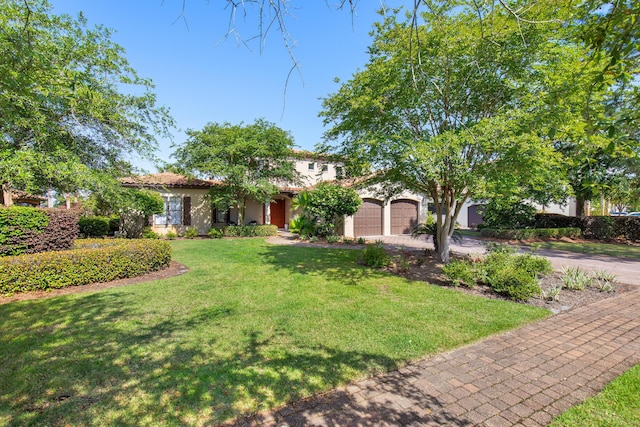1625 San Giovanni Dr, Miramar Beach, FL 32550 - view of front of house featuring an attached garage, driveway, a front yard, and stucco siding