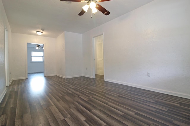 spare room featuring dark wood finished floors, baseboards, and a ceiling fan
