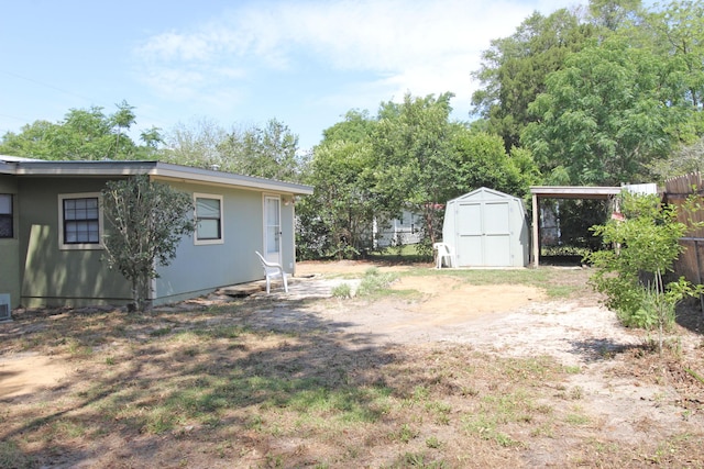 view of yard featuring an outbuilding, fence, and a shed