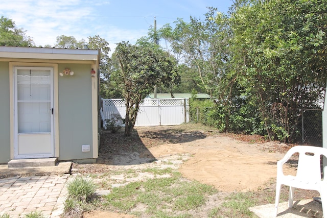 view of yard featuring an outbuilding, a shed, and fence