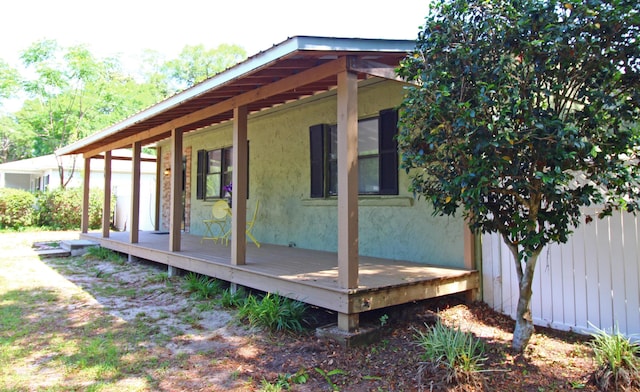 view of side of property featuring a wooden deck and stucco siding