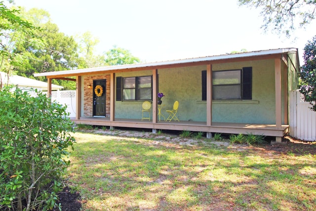 exterior space with a front yard, metal roof, and fence