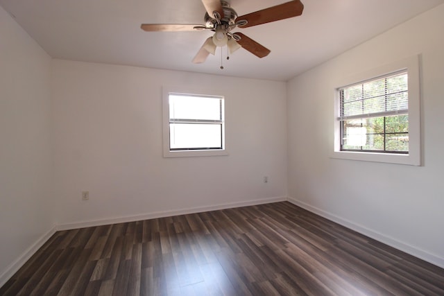 unfurnished room featuring dark wood finished floors, baseboards, and a ceiling fan