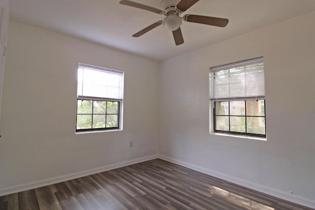 unfurnished room featuring baseboards, dark wood-style flooring, and ceiling fan