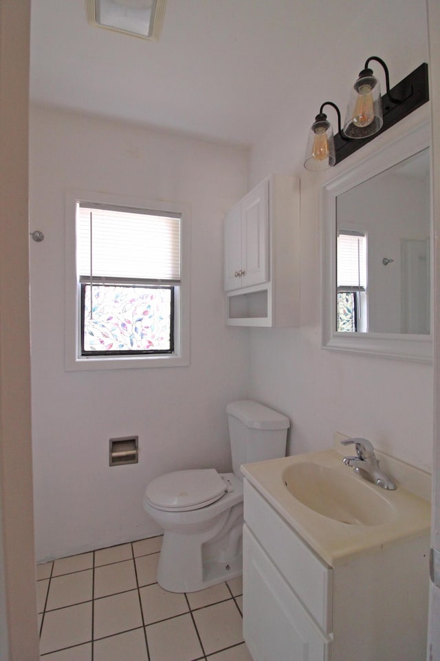 bathroom featuring vanity, toilet, plenty of natural light, and tile patterned floors