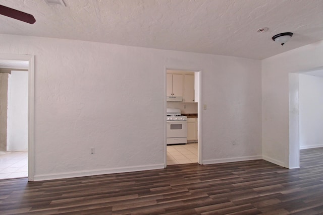 unfurnished room with a textured ceiling, baseboards, a ceiling fan, and wood finished floors