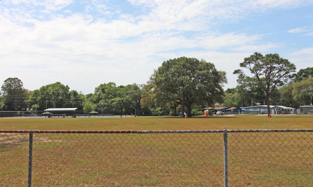 view of property's community with a lawn and fence